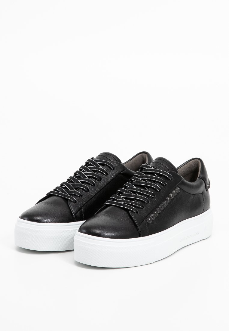 Schwarze Leder-Sneaker mit einer weißen Plateausohle, ausgestattet mit silbernen Schnürsenkeln und einem strukturierten Seitenbereich. Minimalistisches Design, glatte Oberfläche.