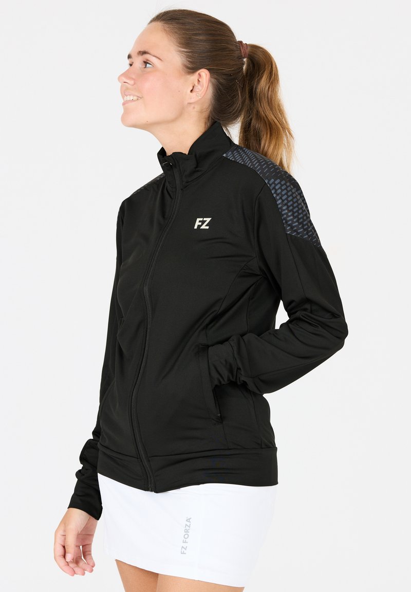 Svart idrottsjacka med hög krage, dragkedja fram och texturerade detaljer på axlarna. Har sidofickor och FZ-logotypen på bröstet.