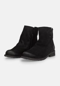 Botas de tobillo de ante negro con puntera lisa, cremallera lateral, tacón bajo y suela texturizada. Presentan un acabado suave y mate y un diseño sencillo.