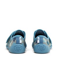 Blue children's shoes with a camouflage fabric pattern, featuring a Velcro strap, rounded toe, and textured rubber sole with logo.