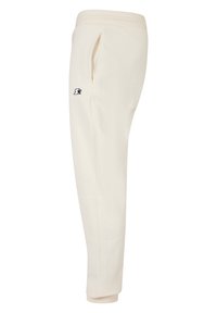 Cremefarvede joggere med elastisk talje, sidelommer og et sort logo patch; lavet af blød, glat stof med en tapered pasform.