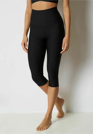 Leggings neri a vita alta in stile capri, caratterizzati da una texture liscia, un design aderente e una lunghezza fino al polpaccio. Adatti sia per l'abbigliamento sportivo che per quello casual.