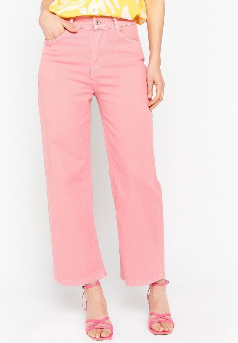 Jeans de pierna ancha rosa, hechos de algodón, con una cintura alta y un diseño estándar de cinco bolsillos, combinados con sandalias rosa de tiras.