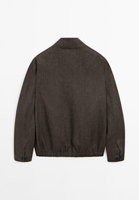 Mörkbrun jacka med texturerat tyg, krage, långa ärmar och elastisk fåll med knäppta manschetter. Endast bakvy.