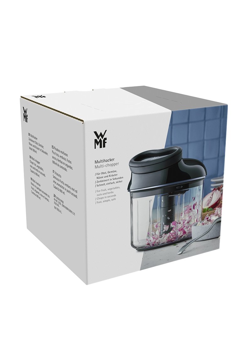WMF Multichopper in einer weißen Box mit schwarzen Akzenten. Klare Behälter, schwarzer Deckel und eine vertikale Klinge aus Edelstahl, die durch die Vorderseite sichtbar ist.