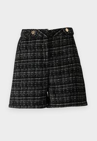 Shorts en tweed noir et blanc avec un motif texturé, dotés de deux boutons à l'avant et d'une coupe ajustée, coupés juste au-dessus du genou.