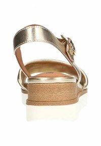 Metalen gouden sandaal met een getextureerde tussenzool, verstelbare enkelband en een decoratieve gesp. Ronde neus en een design met een lichte hak.