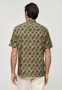 Kortærmet skjorte med et bølgemønster i brune, grønne og cremefarvede nuancer. Fremstillet af letvægtsstof med klassisk krave og lige pasform.