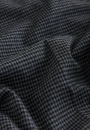 Textilstoff mit einem dunkelgrauen und schwarzen karierte Muster, weiche Textur, mit sichtbaren Falten und Drapierungen.