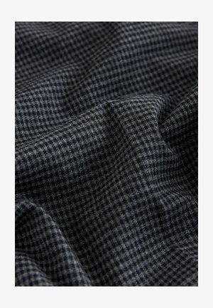 Textilstoff mit einem dunkelgrauen und schwarzen karierte Muster, weiche Textur, mit sichtbaren Falten und Drapierungen.