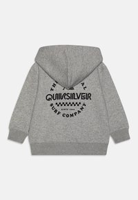 Šedá mikina s kapucí s kulatým černým grafickým designem na zadní straně, na kterém je text "Quiksilver Surf Company", a lemy na rukávech.
