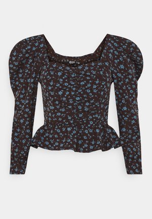 Haut péplum marron à fleurs avec manches longues bouffantes, présentant un corsage froncé et de petits motifs de fleurs bleues partout.