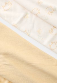 Três amostras de tecido: uma creme com padrões de ovelhas e sol, uma bege, e uma amarelo suave, com texturas suaves e designs subtis.