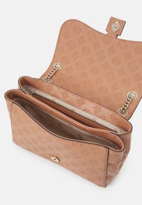 Ramenní taška z opálené kůže s vyraženými vzory, zlatavým řetízkem a zapínáním, dvěma vnitřními přihrádkami a hladkou vnitřní podšívkou.