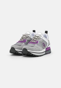 Scarpe sportive grigie con accenti viola, pannelli in rete e dettagli riflettenti. Presentano una suola in gomma testurizzata e lacci metallici.