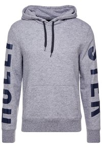 Grå pullover hoodie i texturerat tyg, med en framficka i känguru-stil, svarta dragsko och marinblå logotypdetaljer på ärmarna.