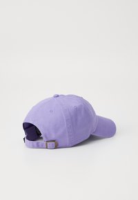 Cappellino da baseball in cotone viola con visiera curva, cinturino regolabile sul retro e bottone cucito sulla parte superiore. Design semplice e monocolore.