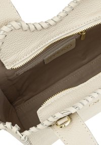 Beežist nahast käekott punutistega, millel on kuldne lukk ja beež kangas sisemus. Sisaldab kaubamärgi sildi sees.