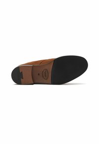 Suela de zapato de ante marrón con un fondo de goma negra lisa, costuras detalladas y un logo circular en la plantilla. Presenta un ligero tacón.
