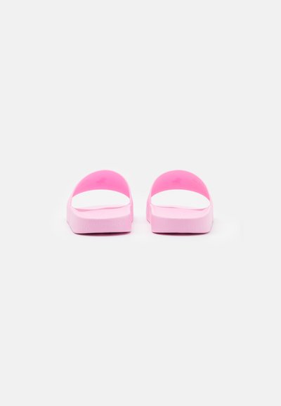 Chinelas de borracha cor-de-rosa com tiras largas, solas planas e uma textura globalmente suave. Design de perfil baixo sem acentos adicionais.