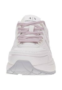 Zapatillas deportivas blancas con cordones morados, parte superior de malla texturizada, cuello acolchado y suela de goma con tracción estriada para un mejor agarre.