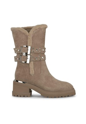 Bottine en daim beige avec un col en fausse fourrure, deux sangles à boucles avec des clous en argent, et un talon épais avec une semelle texturée.