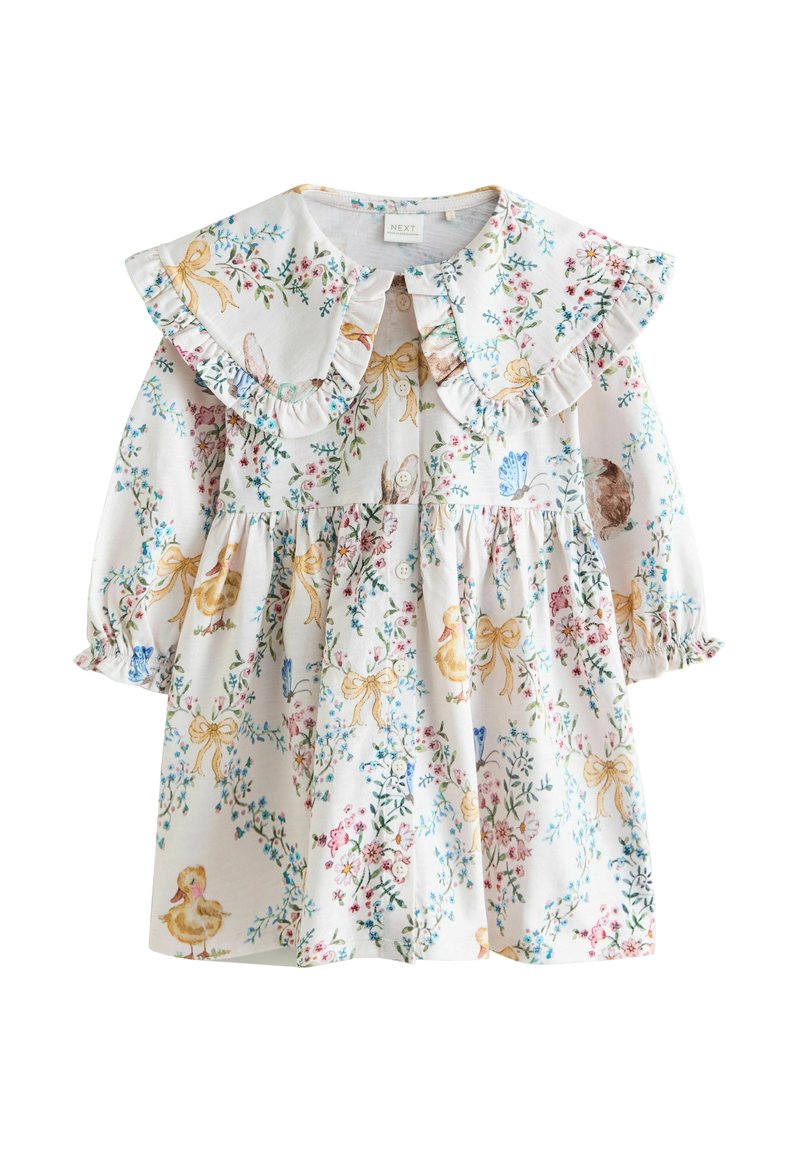 Balta kleita ar ziedu un dzīvnieku rakstiem, ar volānu apkakli, garām piedurknēm un savākta svārku daļa. Izgatavota no viegla auduma.