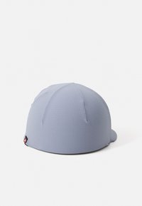 Caps med teksturert lyseblått stoff, har paneler og en liten skjerm, med et svart logomerke på siden. Enkel, rund design.