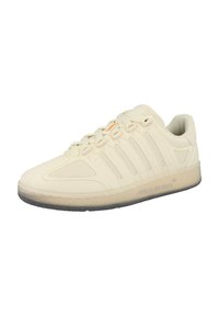 Beige sportsko med en glat overflade, der har laterale striber til ventilation, en rund tå og en gennemsigtig gummisål.