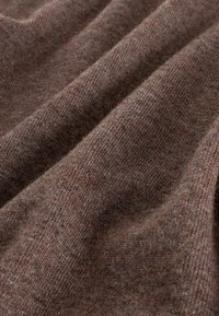 Braun gestrickter Stoff mit einer weichen, strukturierten Oberfläche, die subtile Farbvariationen und ein leichtes Erscheinungsbild aufweist.