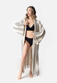 Triibuline kimono-stiilis ruhha kreemjas toonis mustade triipudega, laiad varrukad ja tupsud hemmdel. Kerge, avatud disain.