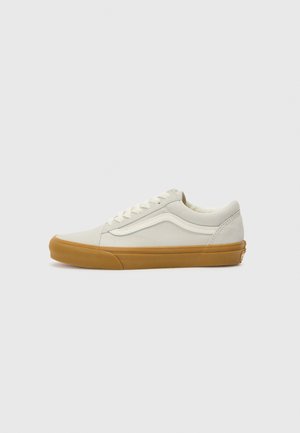 Hvit kanvas sneakers med en teksturert overflate, beige detaljer, såle i gummirubber og runde lisser. Klassisk lavtopp-silhuett.