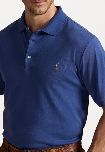 Polo de culoare albastră închisă, realizat din bumbac, cu un guler clasic, trei nasturi și un logo brodat pe pieptul stâng.
