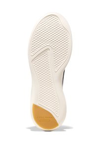 Bílá gumová podrážka obuvi s texturovaným vzorem. Obsahuje žlutý akcent na patě, embossovaný s nápisem "COLE HAAN GRAND 360".