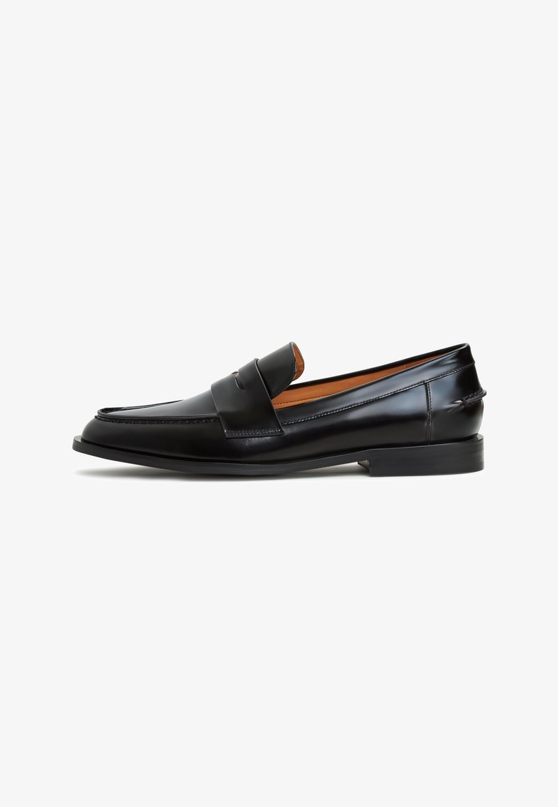 Mocassin penny en cuir noir avec détails cousus, petit talon et doublure intérieure beige, vu de profil sur un fond blanc.