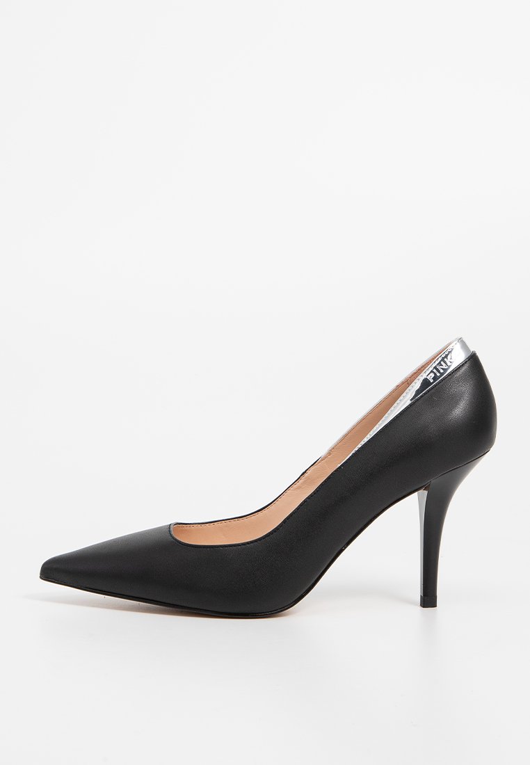 Scarpa décolleté nera con tacco alto, punta affilata, tomaia in pelle liscia e dettaglio metallico argento sul retro del tacco. Design classico.