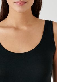 Top nero senza maniche con scollatura ampia e arrotondata. Il tessuto è liscio e leggermente elastico, con bordi ben rifiniti e senza cuciture visibili.