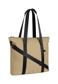 Sac fourre-tout beige en matériau lisse, avec des poignées noires, une fermeture éclair et une bandoulière pour des options de transport polyvalentes.