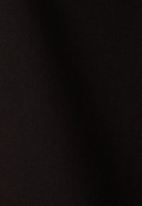 Tessuto nero con una superficie liscia e opaca e una trama densa, che presenta un colore uniforme e solido senza motivi o decorazioni visibili.