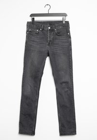 Jeans neri con una leggera texture sbiadita, design a cinque tasche, zip e chiusura con bottone in metallo, appesi a una gruccia nera.