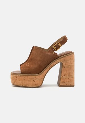 Brune suedegladiator-sandaler med korkblokk hæl, åpen tå-design, justerbar slingback-stropp og gullspenne.