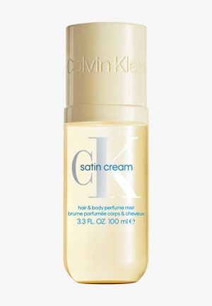 Flacon de parfum en brume pour cheveux et corps Calvin Klein Satin Cream, 100 ml, avec bouchon beige et liquide jaune clair transparent à l'intérieur.