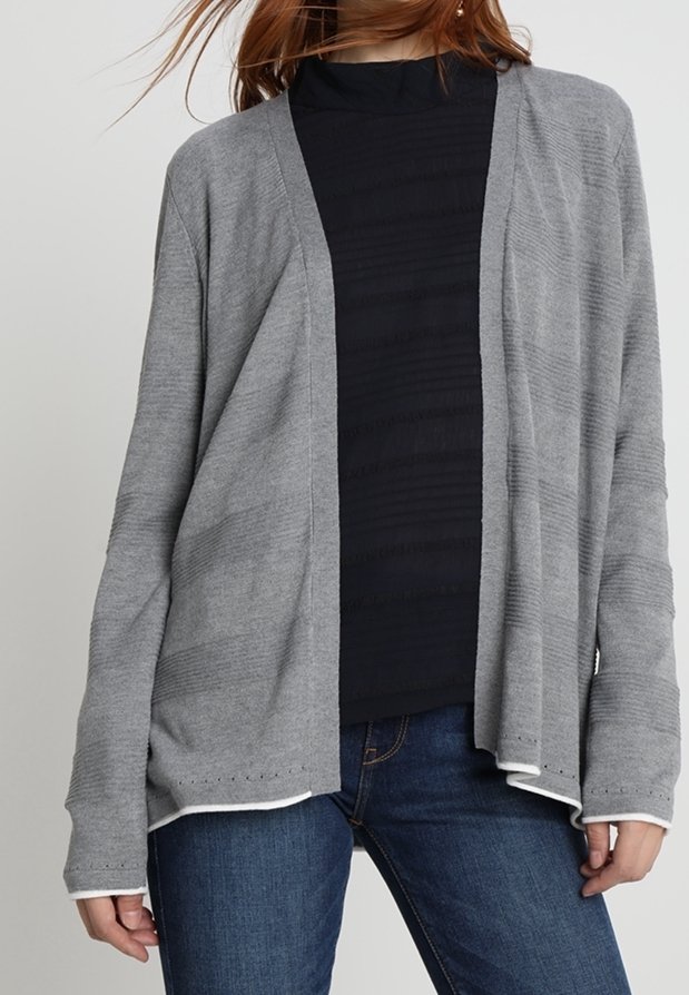 Ljusgrå långärmad cardigan i mjukt tyg med öppen front och subtil ribbad textur. Stylar över en svart topp och blå jeans.