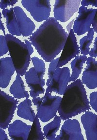 Blauwe en witte stof met een abstract patroon van diamanten, zachte textuur en contrasterende donkere accenten.