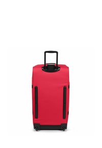 Red hard-shell suitcase with black handle and wheels. Features a smooth texture and vertical side accents. Designed for easy mobility.