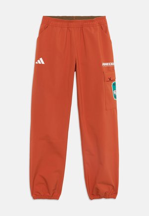 Orangefarbene Adidas-Hose mit elastischem Bund und Bündchen, Minecraft-Logo und Charaktergrafiken auf der rechten Cargotasche und am Oberschenkel.