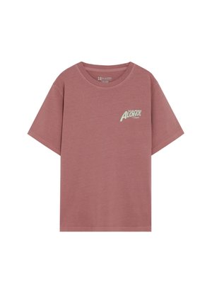 Camiseta de algodón color rosa polvo de manga corta con cuello redondo y pequeño logo blanco "Scalpers Aloha Resort" en el pecho izquierdo.