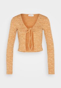 Långärmad kort topp i texturerad orange tyg, med en djup V-ringning och en framknutning. Designen inkluderar ett rutmönster.