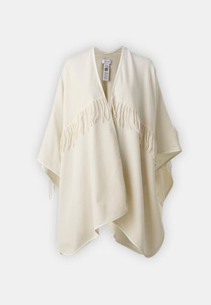 Kremfarget poncho laget av mykt stoff, med V-hals, åpen front og dekorative frynser langs kanten.