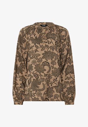 Chemisier beige à manches longues avec des motifs floraux noirs complexes et une patte de boutonnage partielle à l'avant.